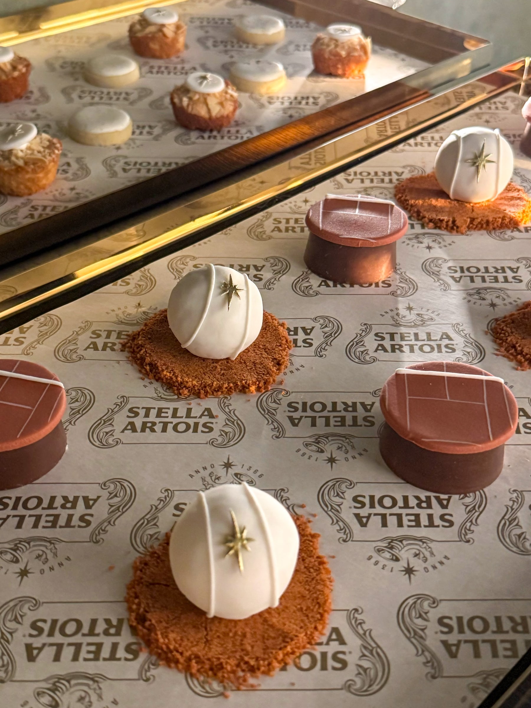 Doces criados para uma ativação de marca, com esferas brancas marcadas pela estrela da Stella Artois